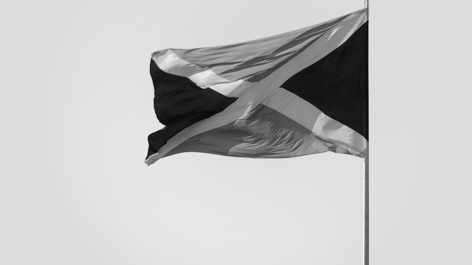 A Jamaican flag flying atop a flagpole