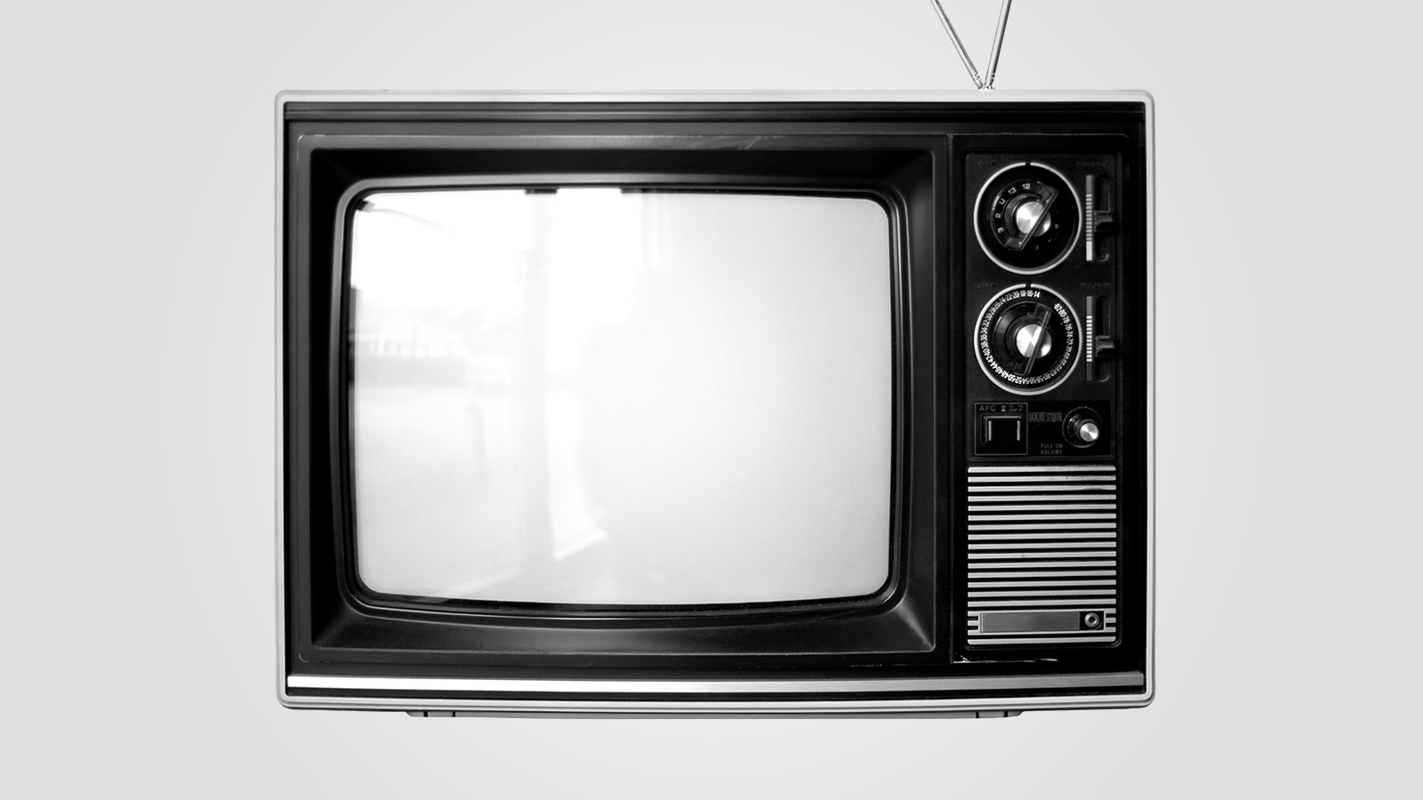 A 1970s-era TV with dials and rabbit-ears antenna