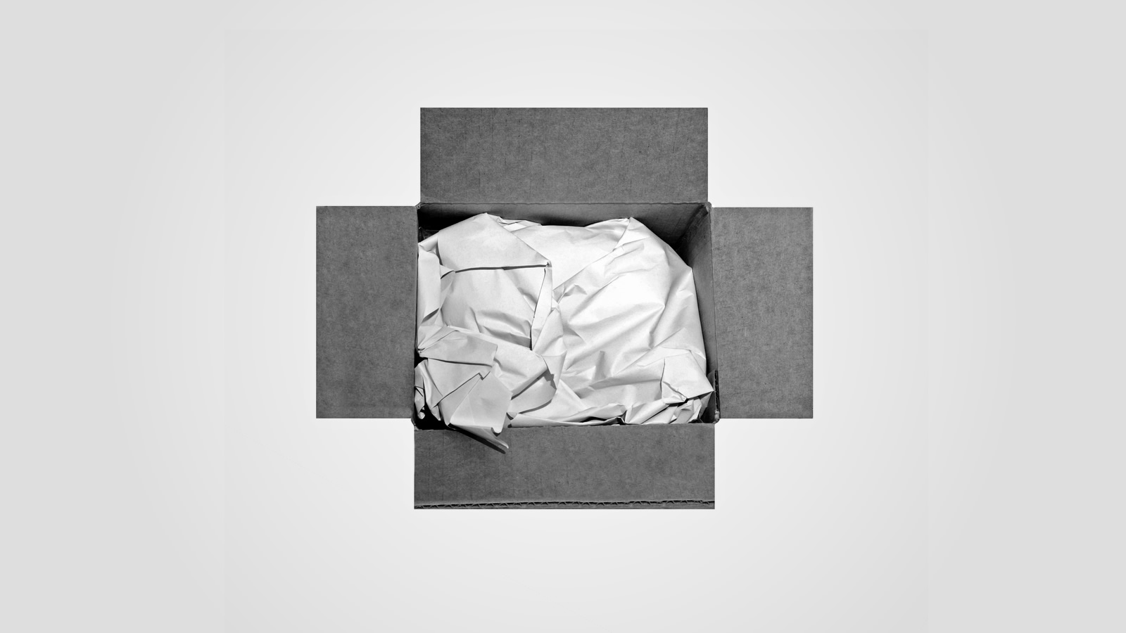 An open cardboard box with its contents wrapped in paper